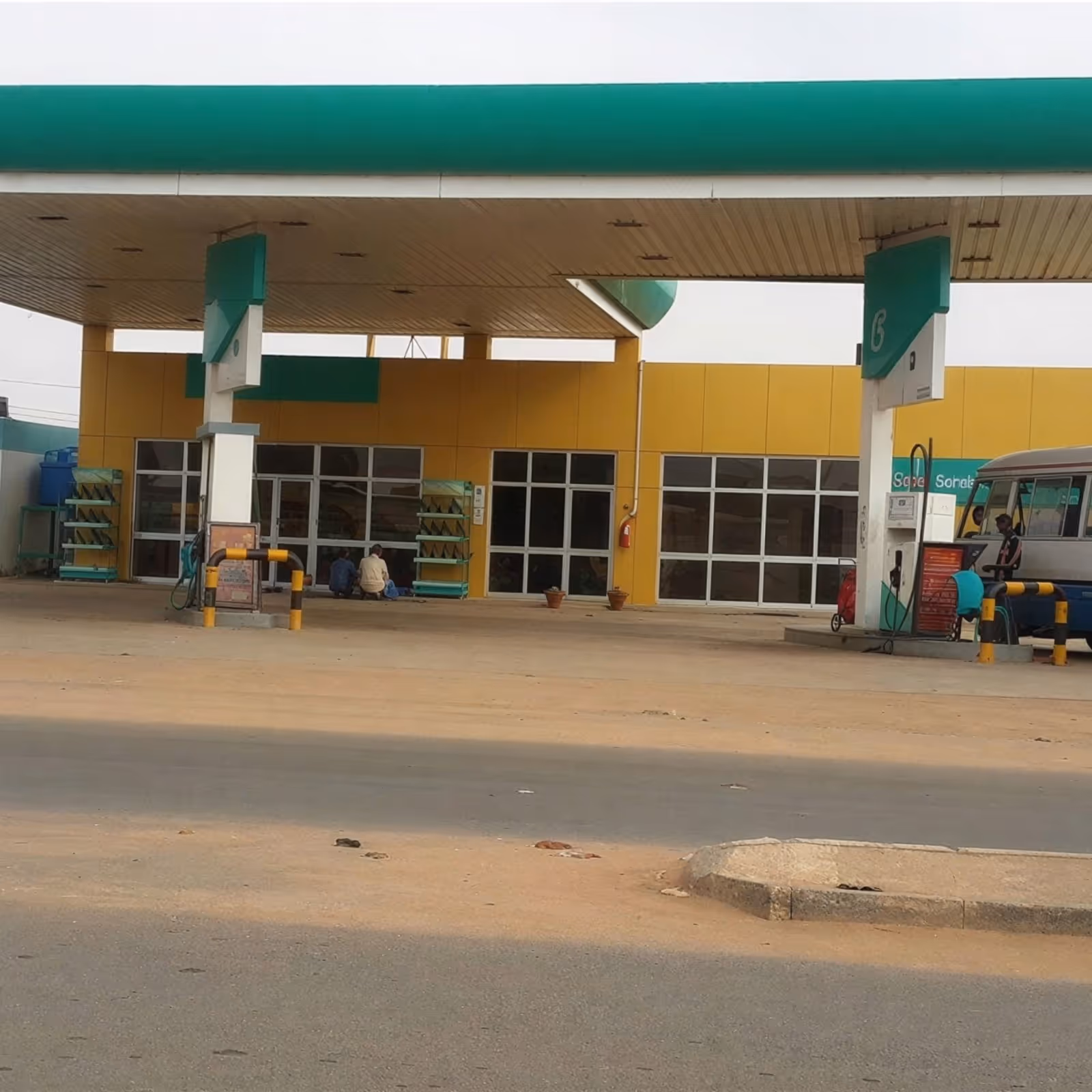 Completed PETRONAS gas station forecourt and canopy with branded fuel pumps and finished site works.